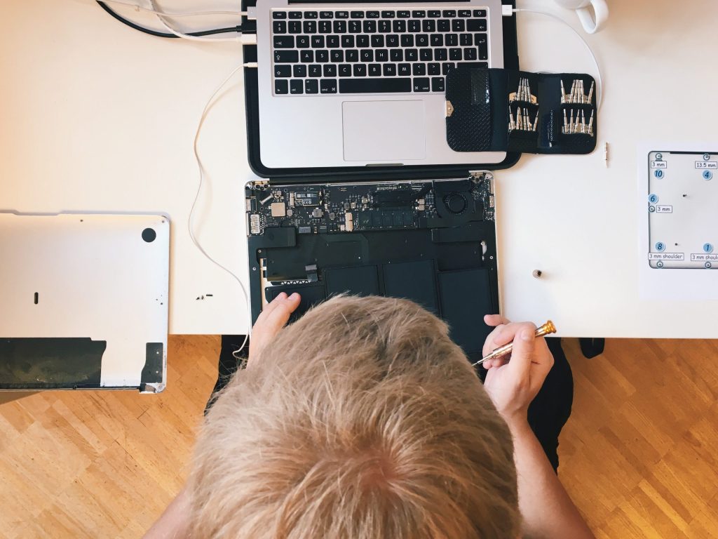 cropped image engineer repairing laptop table