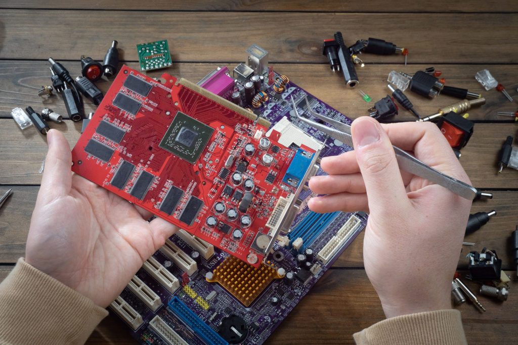hands assembling red circuit board motherboard