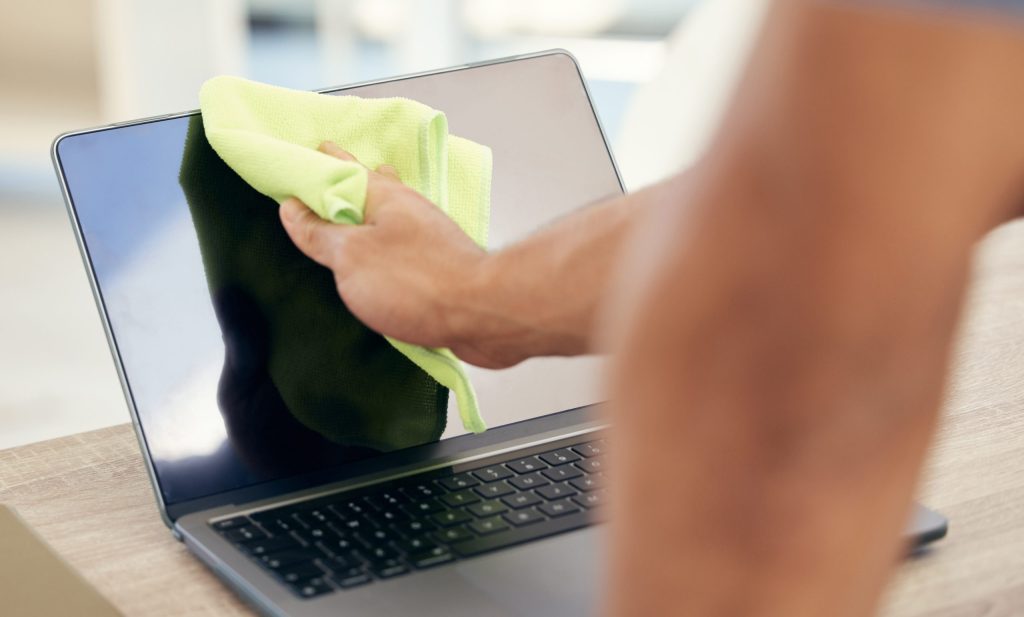 hands cloth person with laptop remove dust cleaning with hygiene bacteria risk company policy employee screen computer with keyboard covid compliance health maintenance