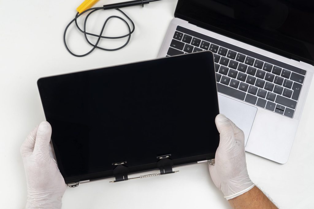 man replaced broken monitor laptop holds it his hands light white room