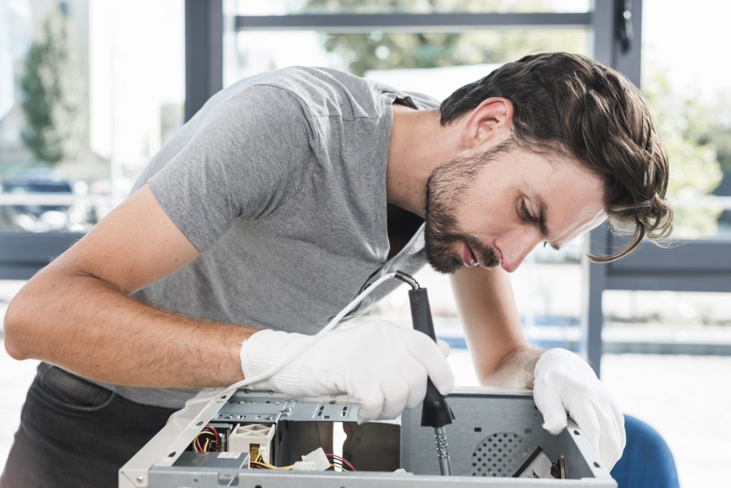 side view young male technician working broken computer