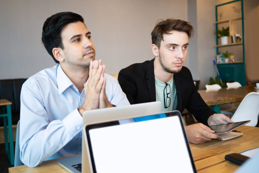 two professionals listening business conference speaker