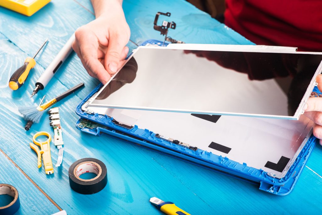 wizard repairs laptop with tools hands blue wooding table top view